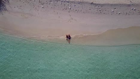 v03929-fliegenden-Drohne-Luftaufnahme-der-Malediven-weißen-Sandstrand-2-Personen-junges-Paar-Mann-Frau-romantische-Liebe-auf-sonnigen-tropischen-Inselparadies-mit-Aqua-blau-Himmel-Meer-Wasser-Ozean-4k