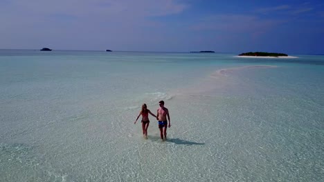 v04000-vuelo-drone-vista-aérea-de-Maldivas-playa-2-personas-pareja-hombre-mujer-amor-romántico-en-la-isla-de-paraíso-tropical-soleado-con-cielo-azul-aqua-agua-mar-4k