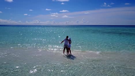 v03920-fliegenden-Drohne-Luftaufnahme-der-Malediven-weißen-Sandstrand-2-Personen-junges-Paar-Mann-Frau-romantische-Liebe-auf-sonnigen-tropischen-Inselparadies-mit-Aqua-blau-Himmel-Meer-Wasser-Ozean-4k