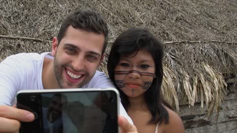 Turista-tomando-una-selfie-con-nativos-de-Brasil---indígenas---en-un-Tupi-Guarani-tribu,-Brasil