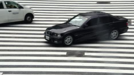 Taxis-und-Autos,-die-Überquerung-der-berühmten-beschäftigt-Shibuya-Bahnhof-Tokio-Kreuzung-in-Japan