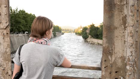 Junge-Mädchen-schaut-auf-den-Fluss-von-der-Brücke.-Kutaissi,-Georgien