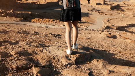 Frau-mit-Rucksack-erkundet-Wüste-Ruinen.-Schöne-europäische-touristische-Spaziergänge-auf-Felsen-und-Sand.-Masada-Israel-4K