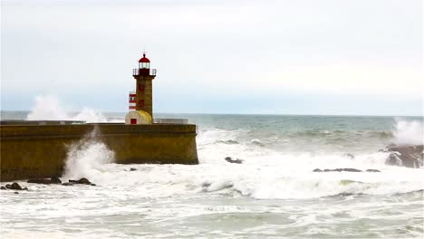 Strong-waves-break-about-the-pier,-the-lighthouse-on-the-shore-of-the-Atlantic-Ocean