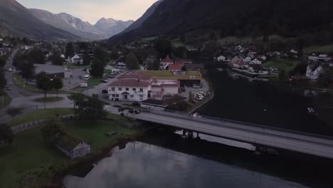 4K-Aerial-View-Small-City-with-Water,-Bridges,-and-Mountains-in-distance