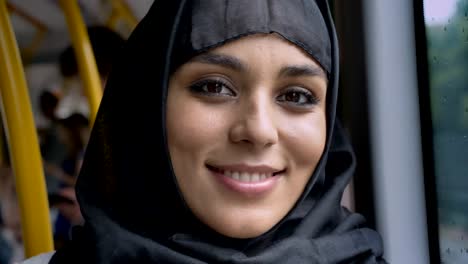 Joven-mujer-musulmana-dulce-en-hijab-está-mirando-a-cámara-en-el-autobús,-concepto-de-transporte,-concepto-urbano,-concepto-de-tiempo,-soñando-con-concepto