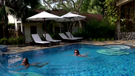 Las-mujeres-nadan-en-la-piscina-al-aire-libre.-Chica-se-zambulle-y-nada-bajo-el-agua