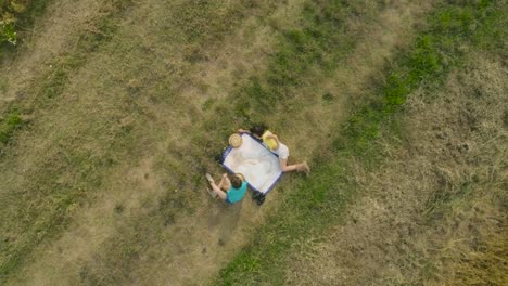 Cute-niñas-jóvenes-exploradores-de-juego-con-mapa-de-Italia-leyendo-y-apuntando-en-trigo-verde-campo-lenta-drone-superior-vista-aérea