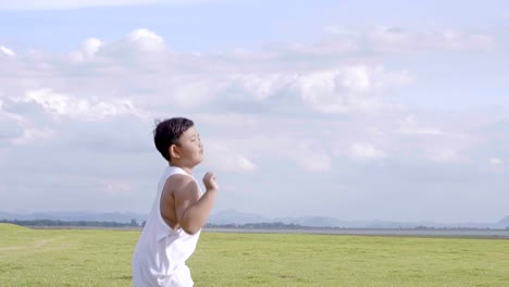 Little-boy-two-old-7-years-Happy-with-a-running-and-throwing-paper-airplane-on-meadow-in-summer-in-nature-Sunset-time.-4K-Video-Slow-motion
