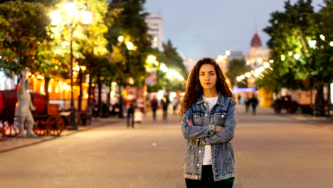 Time-lapse-retrato-de-señora-joven-sola-de-pie-en-la-calle-centro-de-la-ciudad-con-los-brazos-cruzados-mientras-que-multitudes-de-hombres-y-mujeres-pasan.-Concepto-de-soledad-y-tiempo.