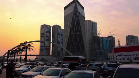 Torres-de-la-ciudad-de-Sharjah,-puente,-calle-al-atardecer