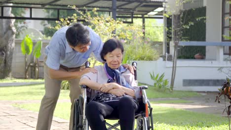 Son-and-daughter-in-law-looking-after-elderly-mother-in-backyard