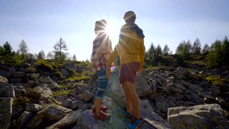 Teamkollegen-helfen-Wanderer-zum-Gipfel.-Paar-Wanderland-Schweiz,-Hand-ausstrecken,-um-weibliche-Wanderer-den-Gipfel-erreichen-zu-helfen.-Eine-helfende-Hand-Konzept