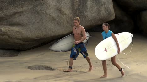 Surfers-walking-out-of-the-water-talking-about-waves