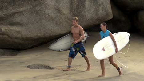 Surfer-zu-Fuß-im-Wasser-über-Wellen