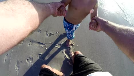 Slow-Motion-POV-of-Father-swinging-happy-child-on-beach.