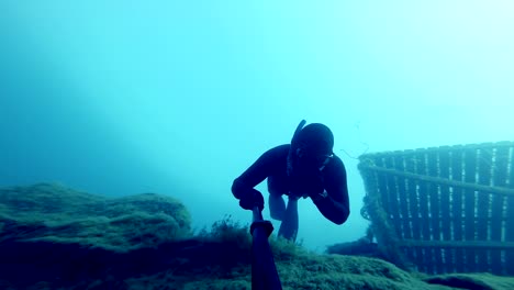 Freediver-Freefalling-en-una-profunda-Cliff-submarino