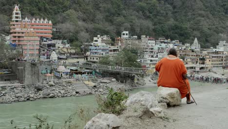 Monk-overlooking-hanging-bridge.