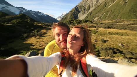 Young-couple-take-self-portrait-on-mountain-background