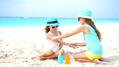 Kids-applying-sun-cream-to-each-other-on-the-beach.-The-concept-of-protection-from-ultraviolet-radiation