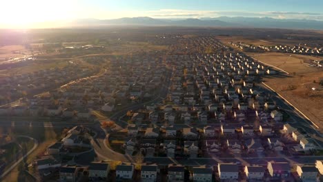 AERIAL:-Row-houses-in-suburban-town-in-valley-surrounded-by-mountains-at-sunrise