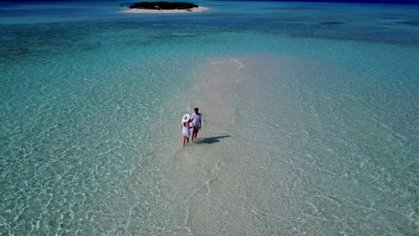 v03952-fliegenden-Drohne-Luftaufnahme-der-Malediven-weißen-Sandstrand-2-Personen-junges-Paar-Mann-Frau-romantische-Liebe-auf-sonnigen-tropischen-Inselparadies-mit-Aqua-blau-Himmel-Meer-Wasser-Ozean-4k