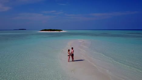 v03899-vuelo-drone-vista-aérea-de-Maldivas-playa-2-personas-pareja-hombre-mujer-amor-romántico-en-la-isla-de-paraíso-tropical-soleado-con-cielo-azul-aqua-agua-mar-4k