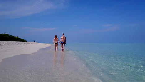 v03864-vuelo-drone-vista-aérea-de-Maldivas-playa-2-personas-pareja-hombre-mujer-amor-romántico-en-la-isla-de-paraíso-tropical-soleado-con-cielo-azul-aqua-agua-mar-4k