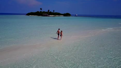 v04027-vuelo-drone-vista-aérea-de-Maldivas-playa-2-personas-pareja-hombre-mujer-amor-romántico-en-la-isla-de-paraíso-tropical-soleado-con-cielo-azul-aqua-agua-mar-4k