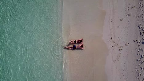 v04022-vuelo-drone-vista-aérea-de-Maldivas-playa-2-personas-pareja-hombre-mujer-amor-romántico-en-la-isla-de-paraíso-tropical-soleado-con-cielo-azul-aqua-agua-mar-4k