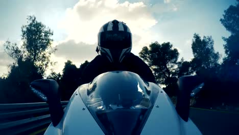 POv-shot-of-a-man-riding-on-a-white-sports-motorcycle-on-a-curved-road