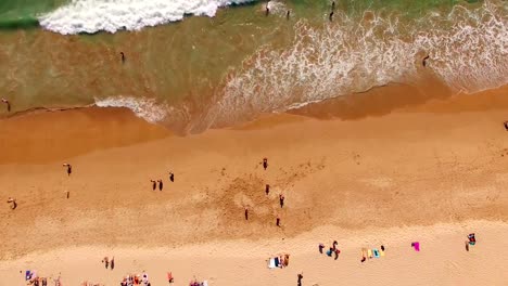 People-rest-on-a-beautiful-sandy-beach-in-Portugal,-Praia-do-Beliche,-Sagres,-aerial-view