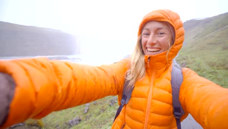 4K-Selfie-portrait-of-young-woman-near-huge-waterfall,-Iceland