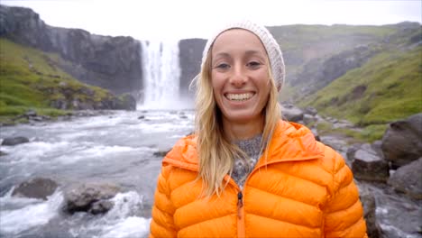 Retrato-de-frente-de-mujer-de-pelo-rubio-de-la-magnífica-cascada-en-Islandia