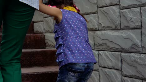 A-young-woman-with-a-little-daughter-climbs-the-stairs.