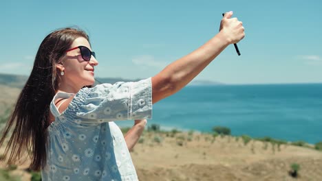 Portrait-of-elegant-European-traveler-woman-taking-selfie-using-smartphone