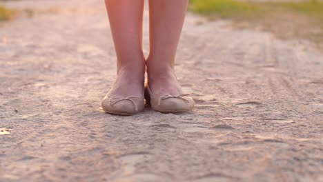 Frau-Füße-in-flachen-Schuhen-springen-im-Straßenstaub.