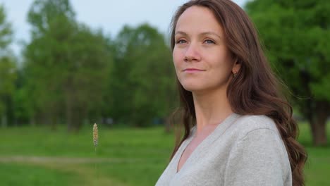 Junge-Frau-mit-Grashalm-Blick-auf-Sonne