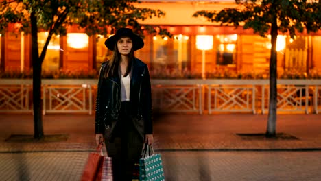 Zoom-Time-lapse-de-chica-guapa-en-la-situación-de-la-ropa-de-moda-con-bolsas-de-compras-en-calle-muy-transitada-y-mirando-a-cámara-cuando-multitudes-de-personas-están-pasando.