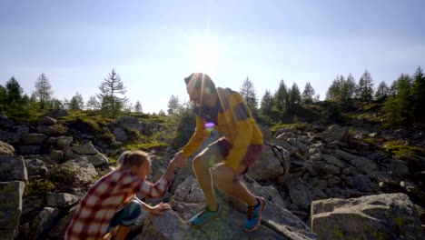 Teamkollegen-helfen-Wanderer-zum-Gipfel.-Paar-Wanderland-Schweiz,-Hand-ausstrecken,-um-weibliche-Wanderer-den-Gipfel-erreichen-zu-helfen.-Eine-helfende-Hand-Konzept