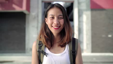 Mujer-alegre-hermosa-joven-asiática-backpacker-esta-feliz-sonriendo-a-la-cámara-mientras-viaja-a-Chinatown-en-Beijing,-China.-Estilo-de-vida-mochila-concepto-de-vacaciones-de-viajes-turísticos.