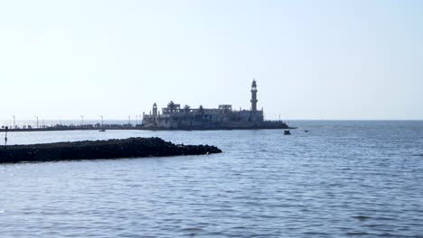 Vista-distante-de-edificio-/-monumento-en-medio-del-mar-de-Bombay.