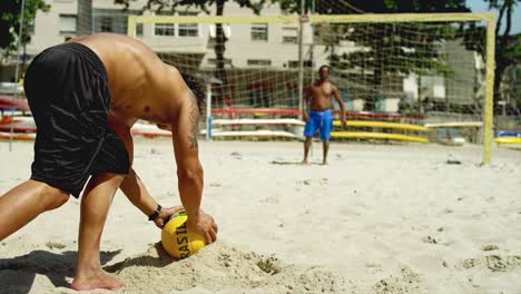 Friends-practice-kicking-a-goal-on-a-beach-in-Brazil.