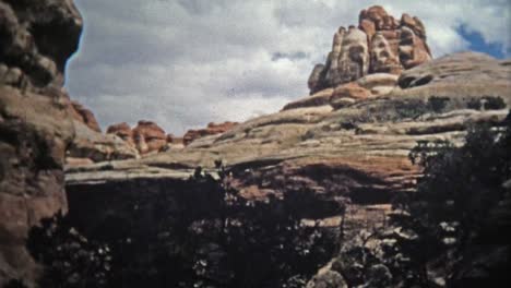 CANYONLANDS,-UTAH--1971:-Man-hiking-narrow-canyon-trails-rock-formations.