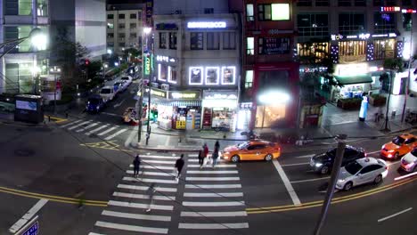Timelapse-of-cars-and-pedestrians-traffic-on-night-road-in-Seoul,-South-Korea