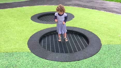 Happy-little-girl-jumps-and-bounce-in-slow-motion-on-outdoor-trampoline