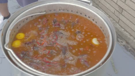 Man-Puts-a-Lid-on-Large-Metal-Pot-of-Boiling-Crawfish