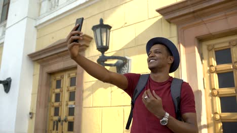 African-american-tourist-man-having-online-video-chat-using-his-smartphone-camera-while-travelling-in-Europe