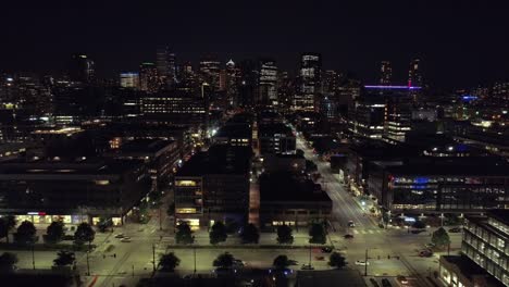 Floating-Aerial-of-American-Major-City-at-Night-with-People-Driving-on-Lit-Streets