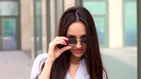 Sexy-girl-looking-at-camera-from-under-sunglasses.